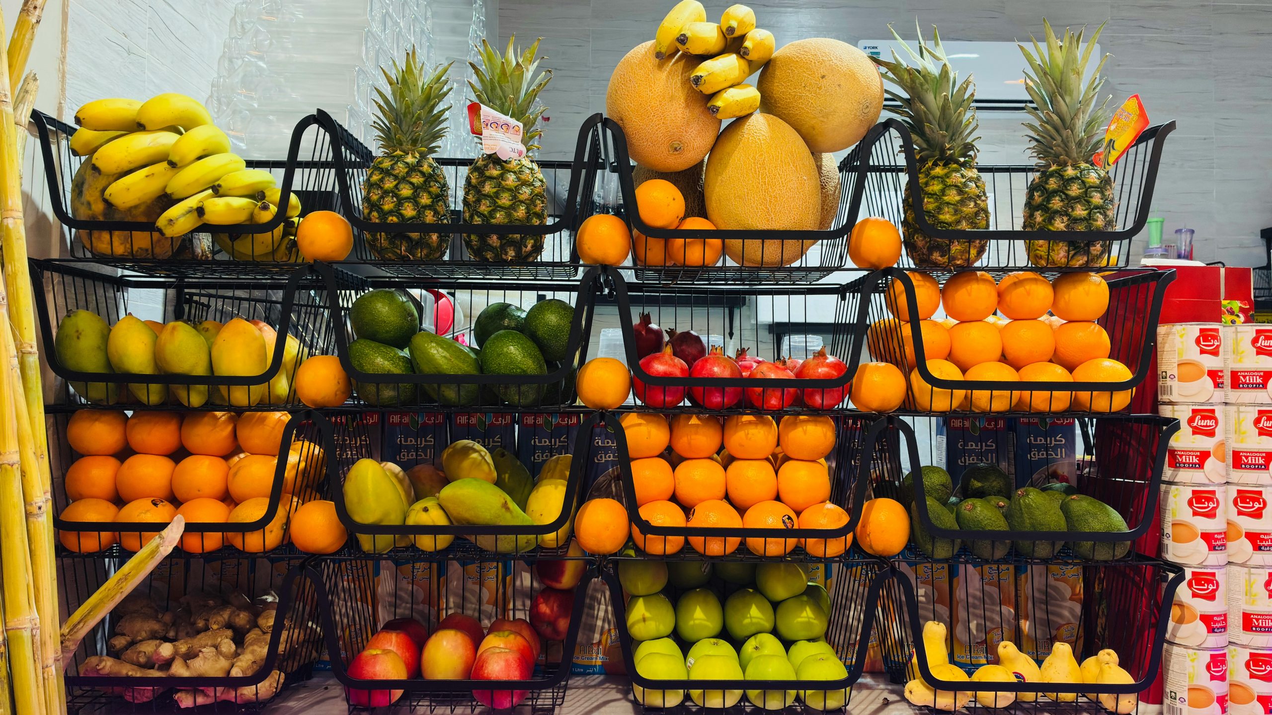Colorful variety of fresh fruits neatly stacked in a local market display.